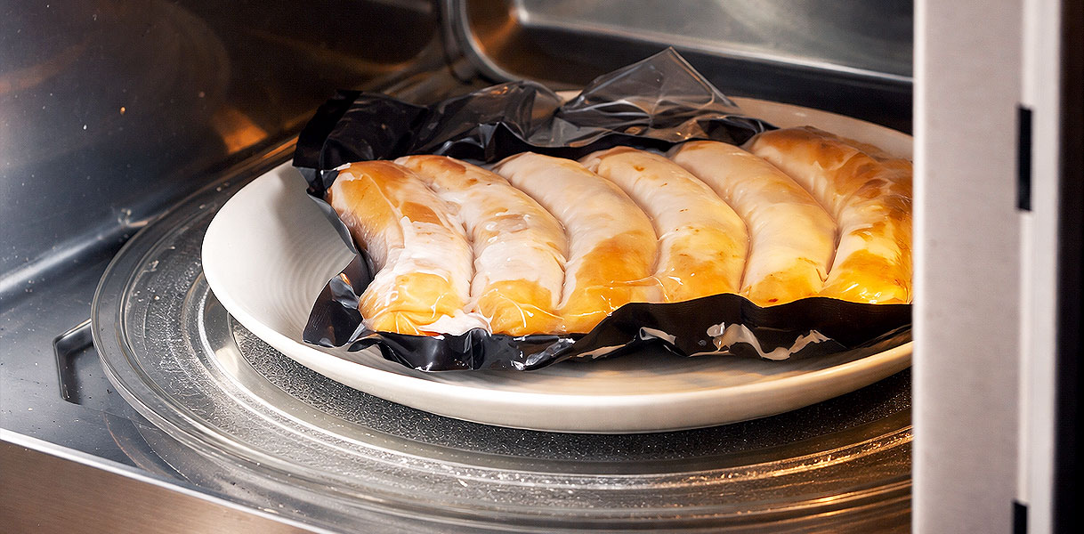 Kwetsbaar gebak op bord dat langzaam wordt opgewarmd in magnetron op 100 tot 300 watt voor delicate gerechten