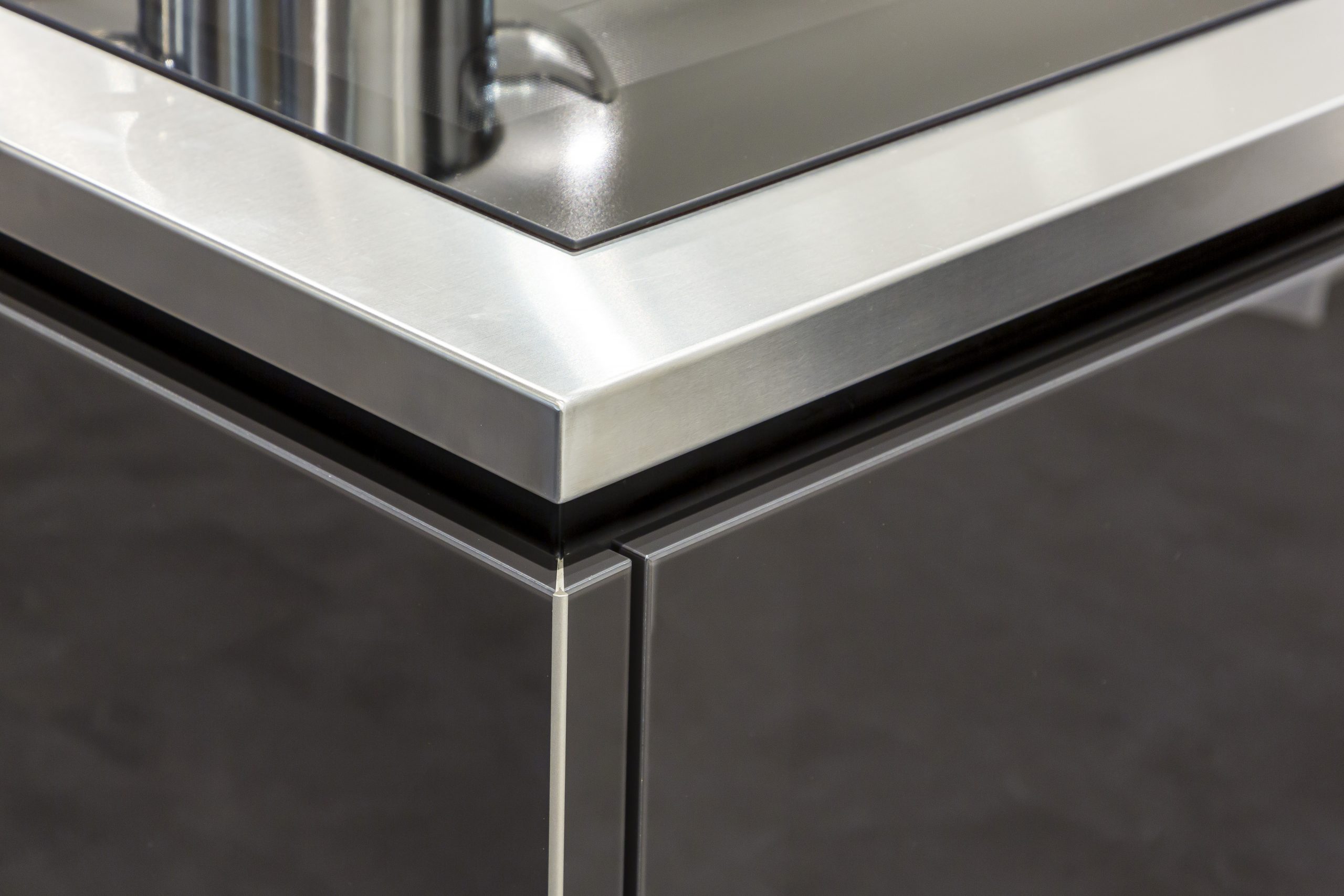 De afwerking van de glazen keukenfronten in de kleur lavazwart