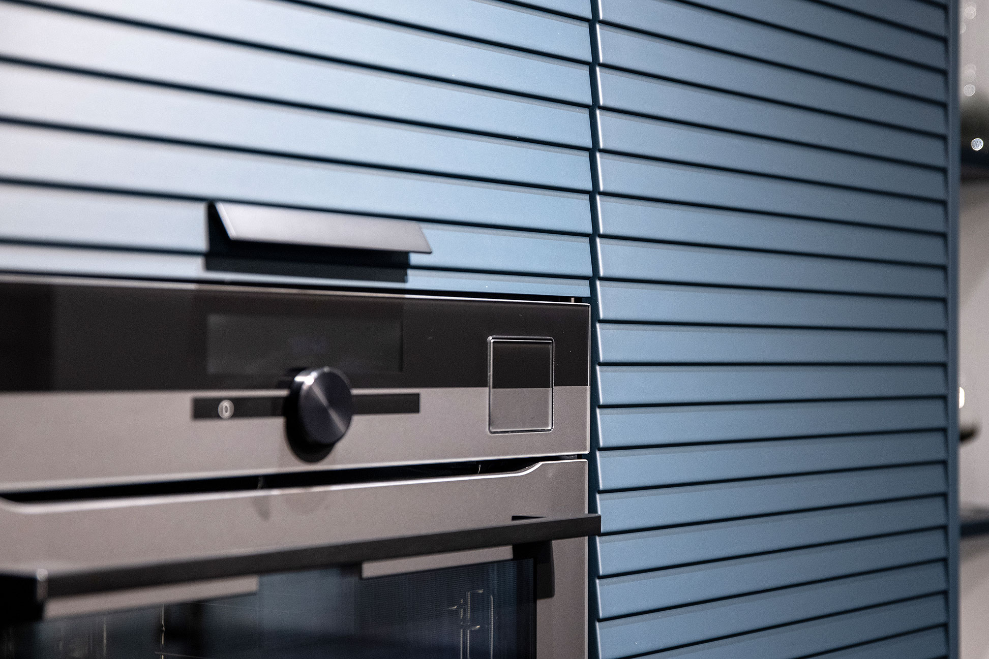 De in mat zwart uitgevoerde greepjes op de lamellen fronten - Bemmel & Kroon keukens