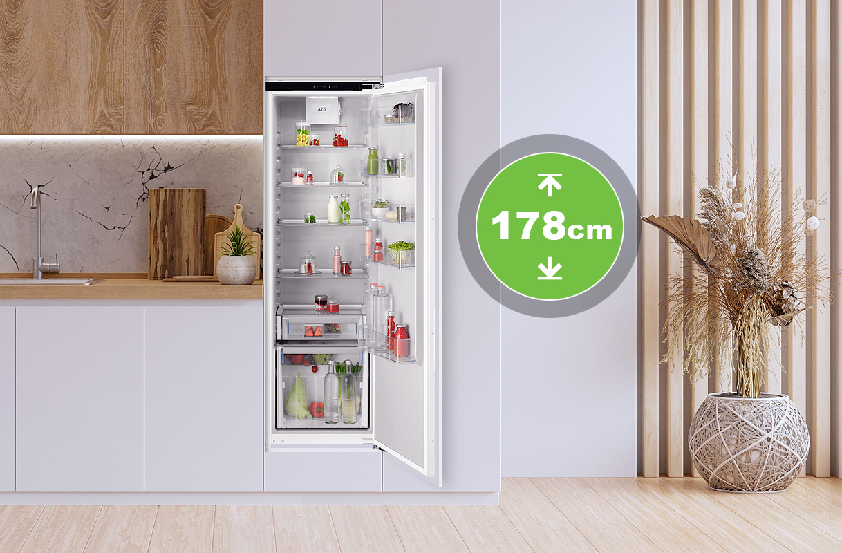 Inbouwkoelkast van 178 cm hoogte in moderne keuken met open deur en volle koelruimte.