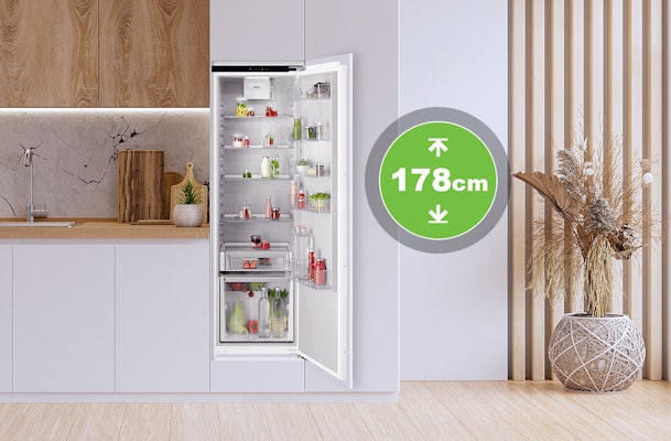 Inbouwkoelkast van 178 cm hoogte in moderne keuken met open deur en volle koelruimte.