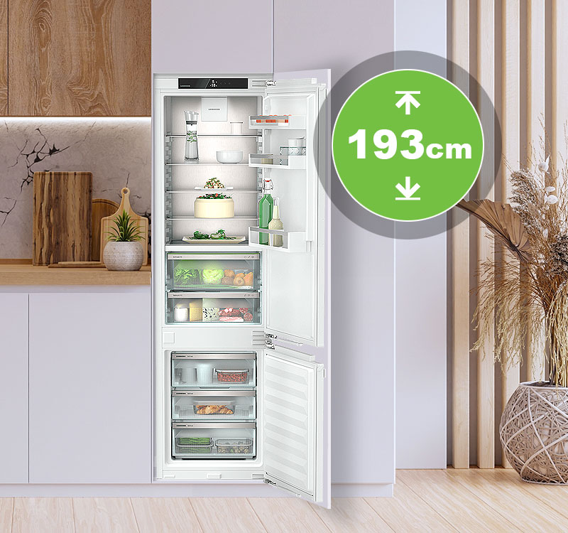 Inbouwkoelkast van 193 cm hoogte in moderne maatwerkkeuken met open deur en ruime koel- en vriesindeling.