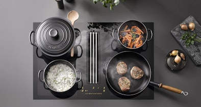 Miele inductiekookplaat met 2 PowerFlex XL-zones met meerdere pannen en een braadslede op het kookoppervlak