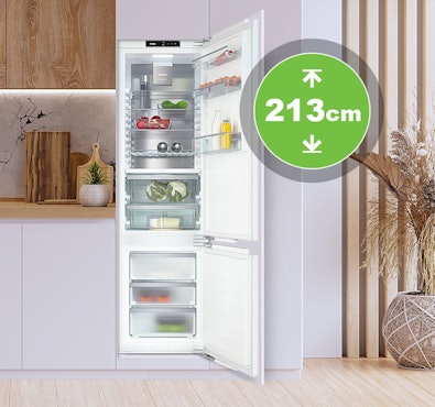 Inbouwkoelkast van 213 cm hoogte in maatwerkkeuken met open deur en ruime koel- en vriesindeling.