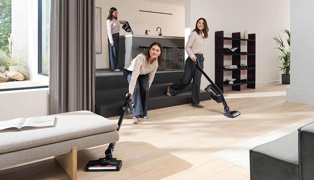 Drie vrouwen gebruiken Miele Triflex HX3 in comfortstand, reikwijdtestand onder meubels en als handunit in dezelfde woonruimte