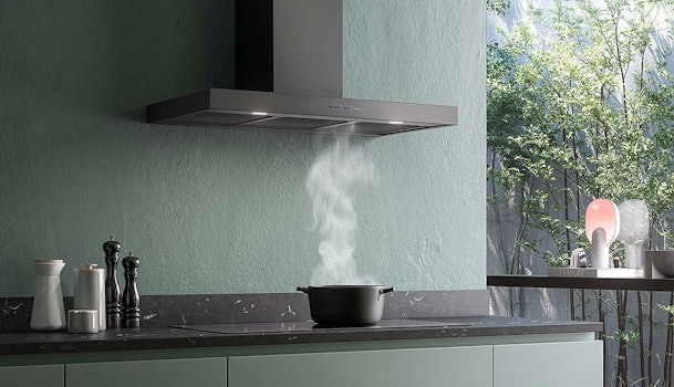Afzuigkap van 60 cm boven een 60 cm inductiekookplaat met opstijgende kookdamp in een moderne keuken.