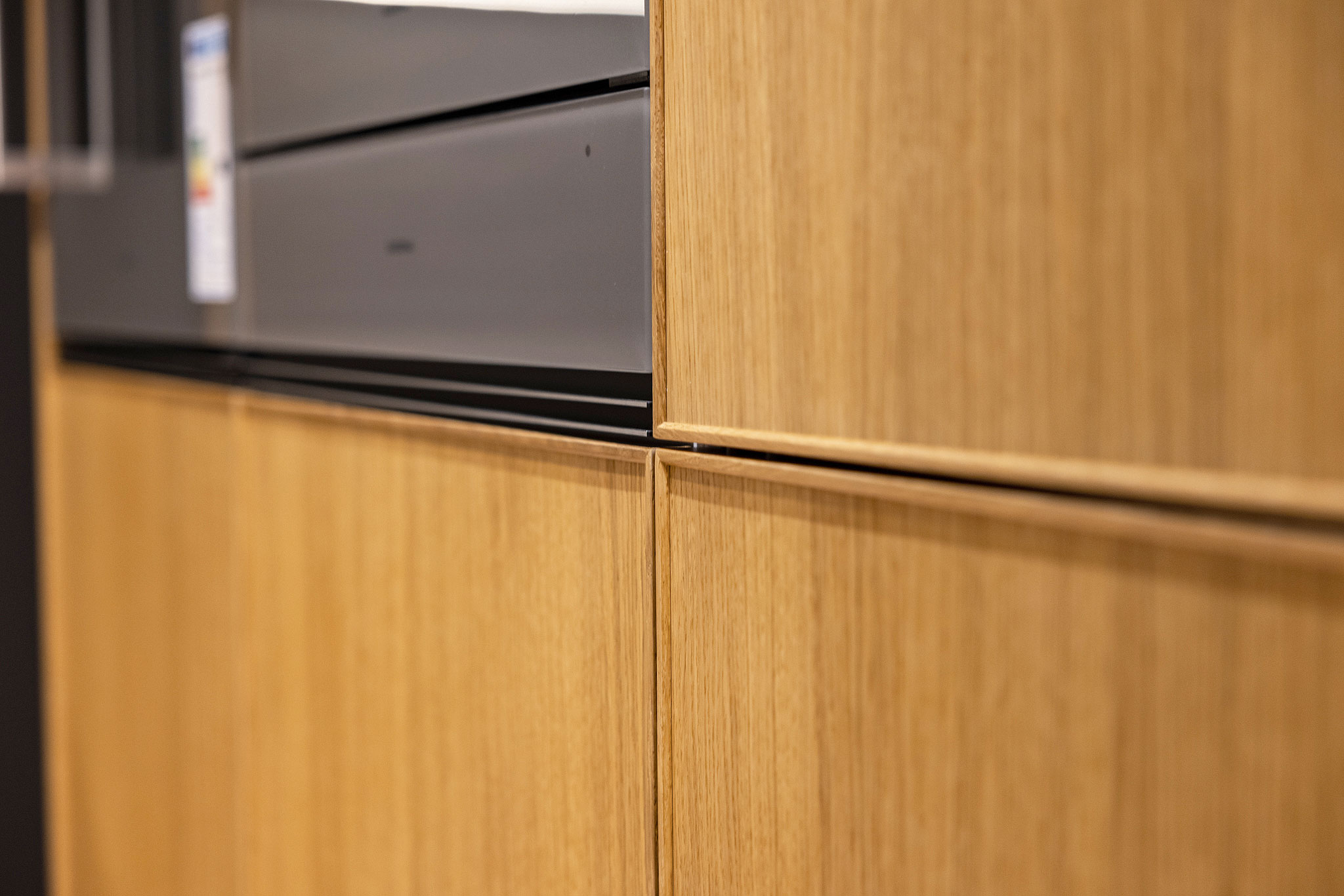 Houten fronten met een designlijst geven de keuken een huiselijke charme met een nostalgisch tintje.