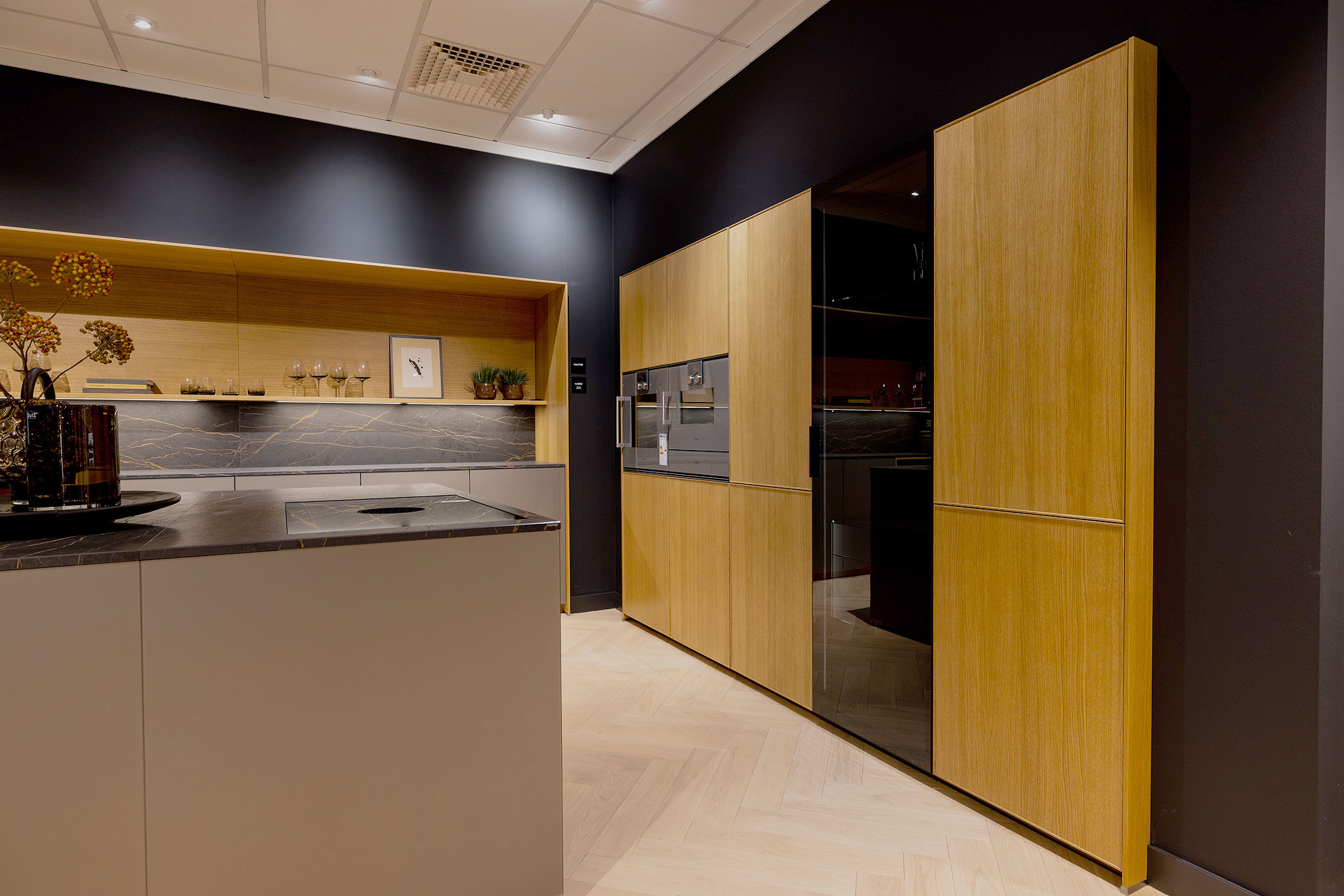 In de rij oogt het eiken fineerfront met smalle, rondom lopende lijst rustig en ordelijk.