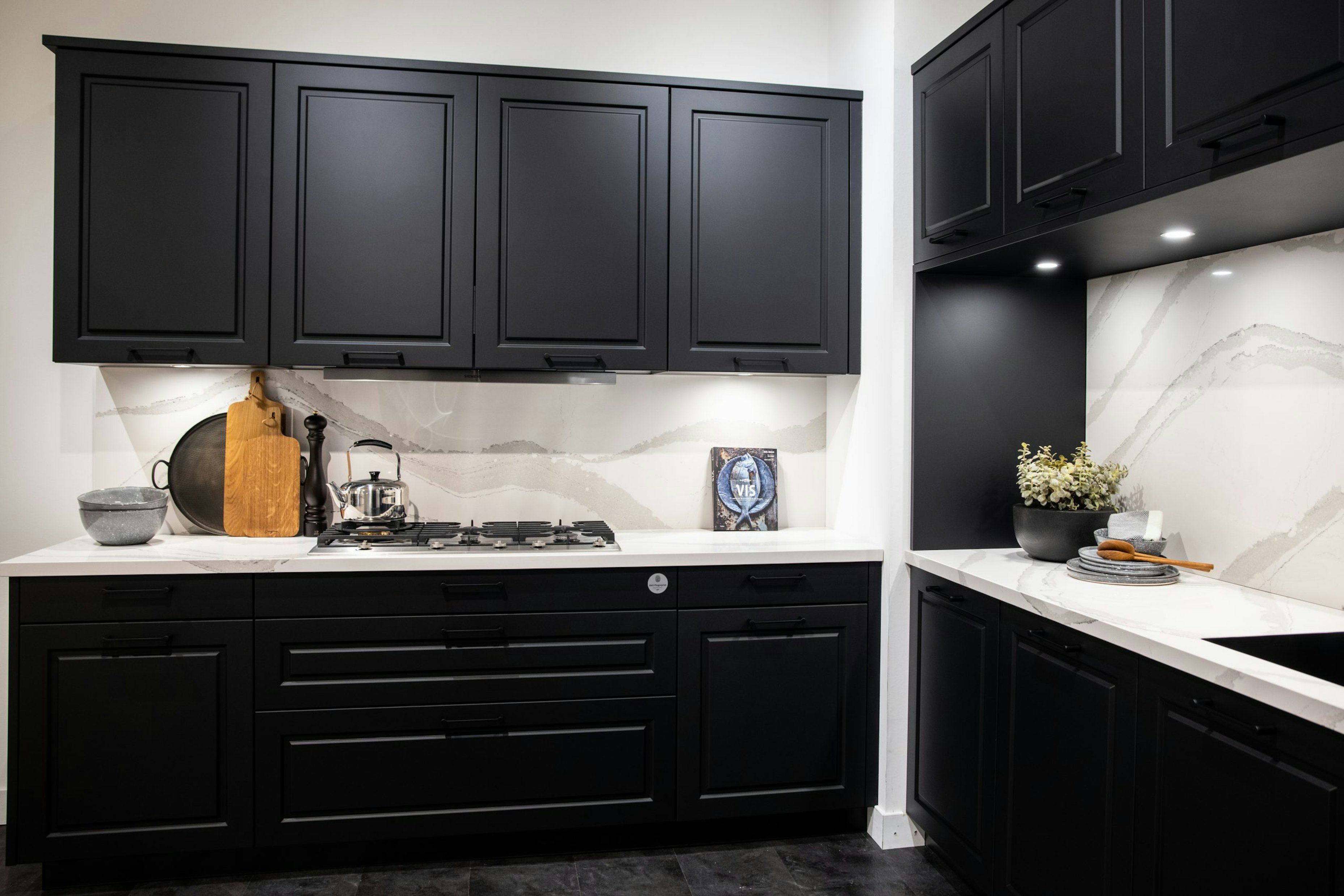 De keukenbladen, achterwand en zwarte fronten bieden een mooi contrast - Bemmel & Kroon keukens