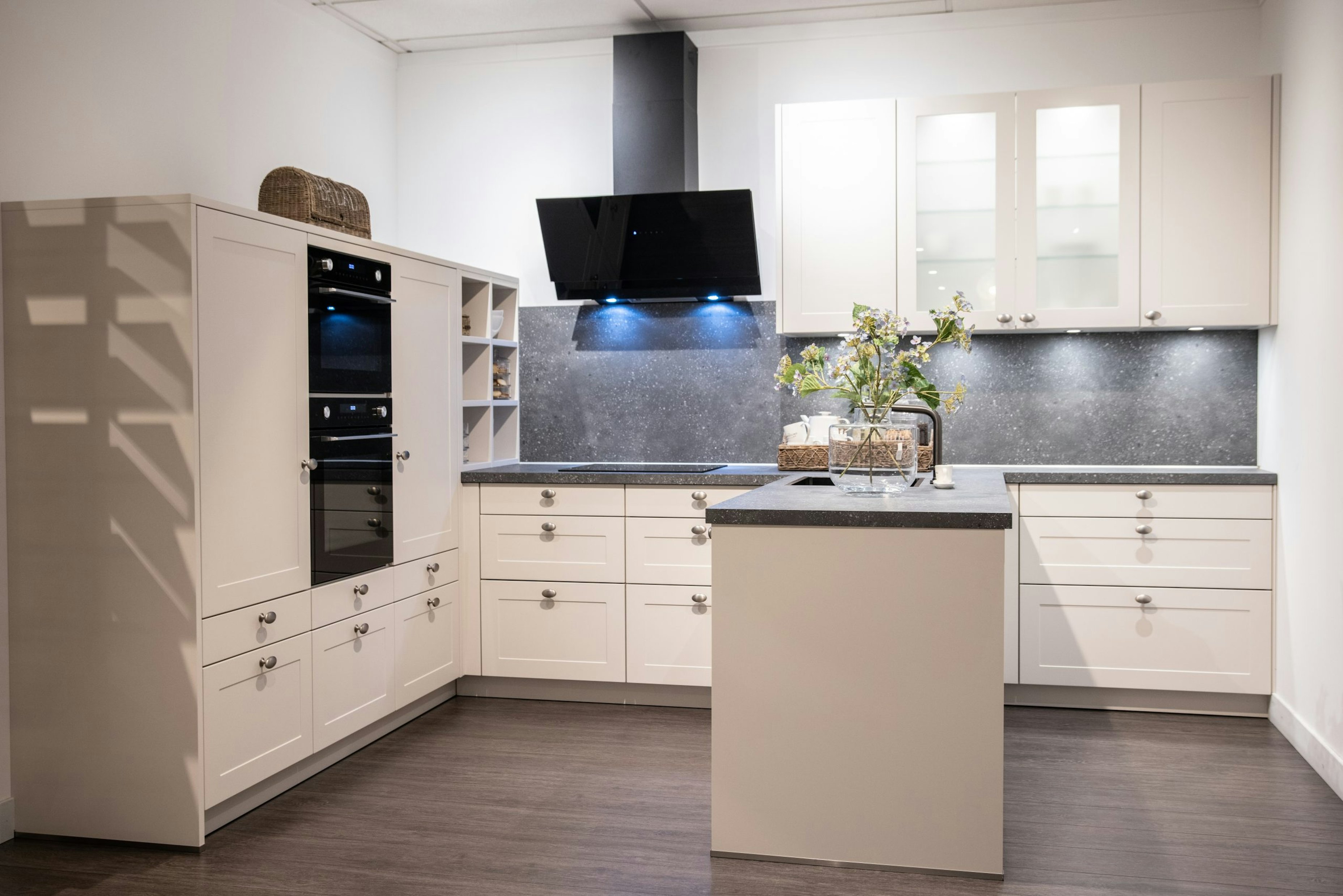 De zwarte inbouwapparatuur en schuine afzuigkap geven deze keuken een modern landelijke look - Bemmel & Kroon keukens