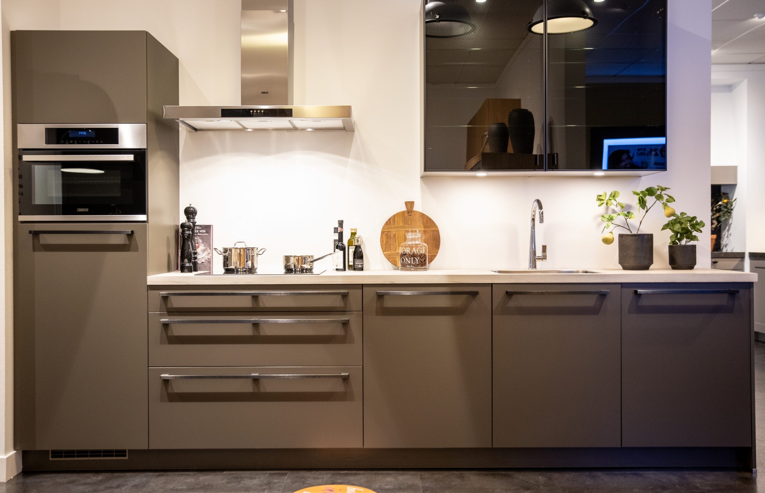 Rechte mat bruine keuken met rvs design grepen - Bemmel & Kroon keukens