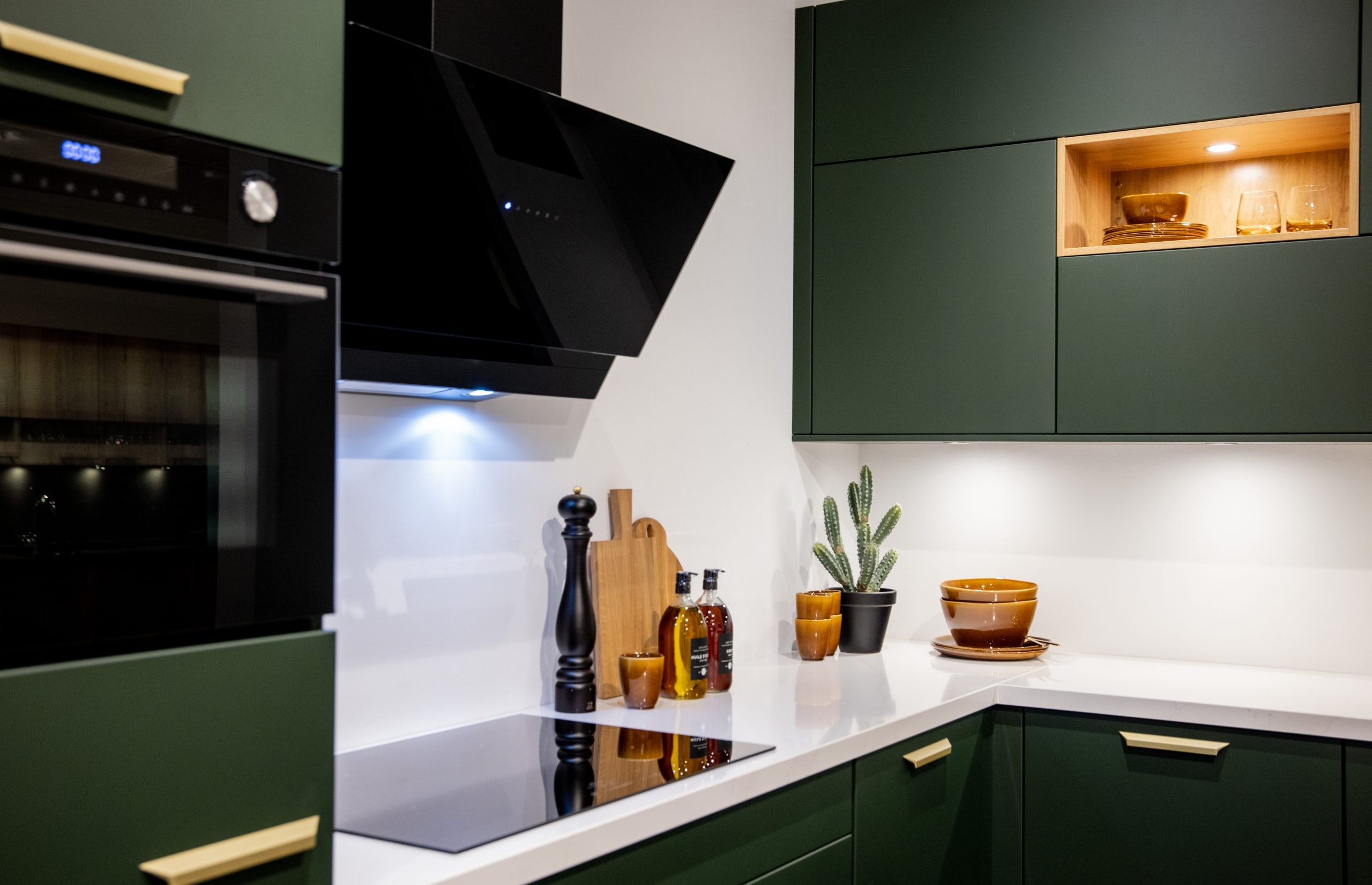 Het witte composiet werkblad vormt een mooi contrast met de mat groene fronten - Bemmel & Kroon keukens