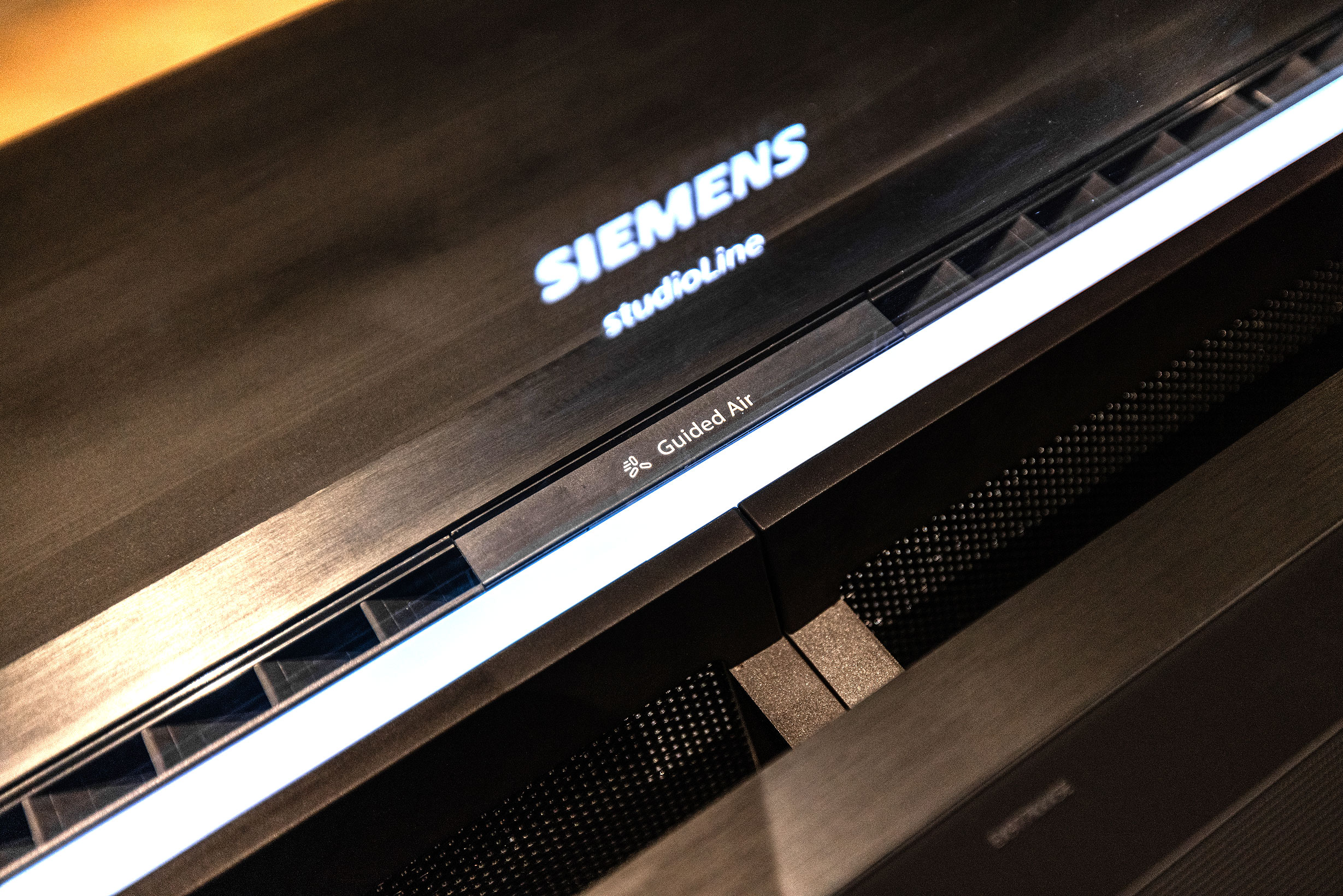 De uitschuifbare afzuigkap is van glas en kan in verschillende kleuren worden verlicht.