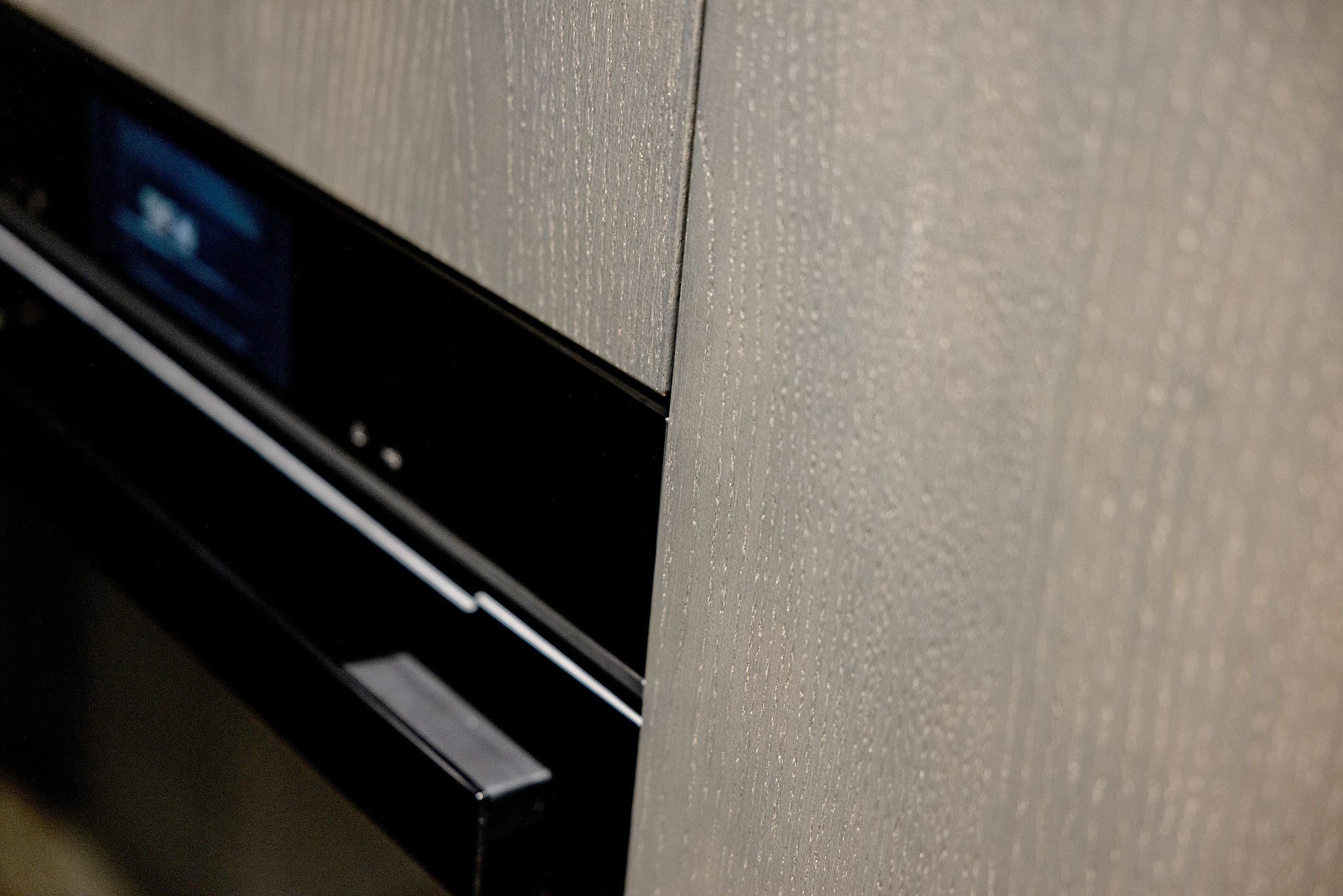 Close-up van de in parelgrijs uitgevoerde knoestig eiken geborstelde fronten.