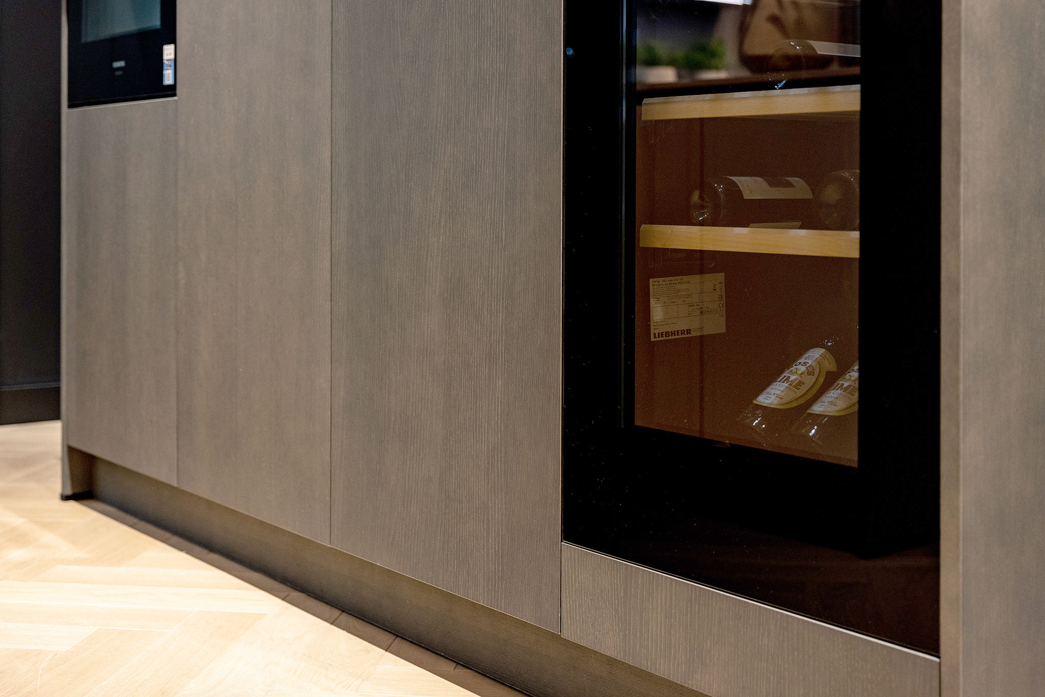 De luxe uitstraling van deze eilandkeuken wordt door de wijnkoelkast extra geaccentueerd.