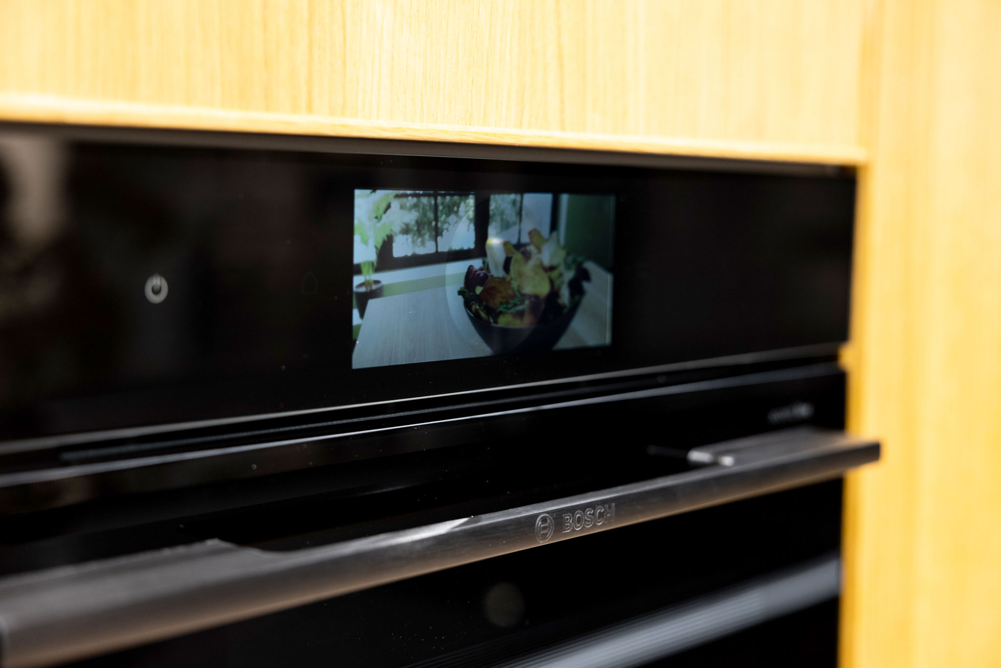 De in de hoge houten kastenwand ingebouwde Bosch oven.