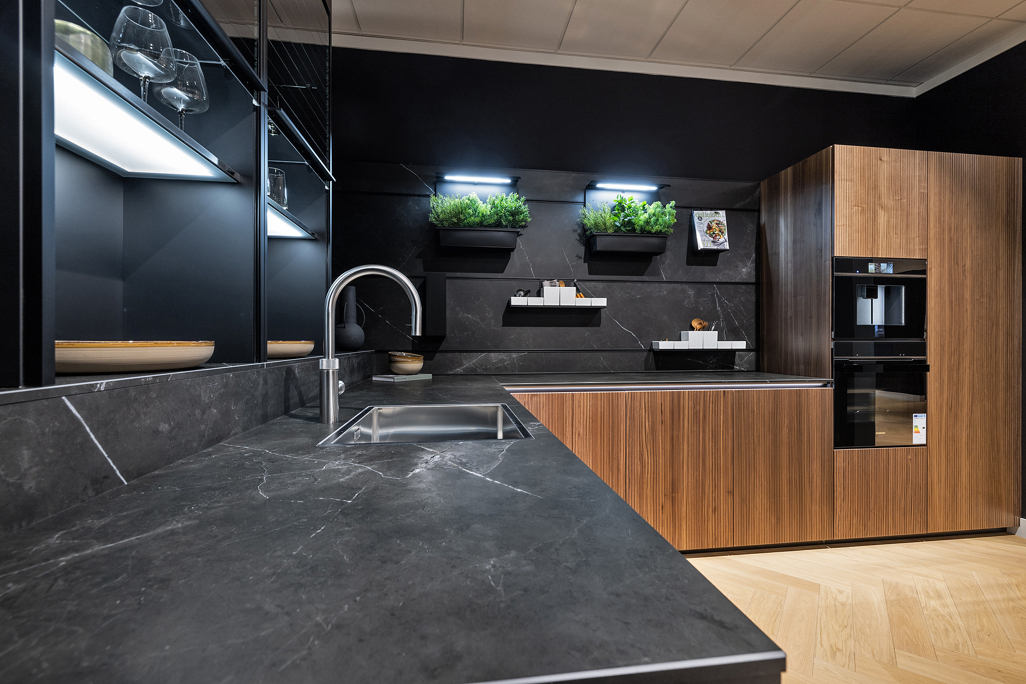 Zowel de werkbladen, achterwand en de meeste fronten zijn van keramiek en uitgevoerd in de kleur Marmer Nero.