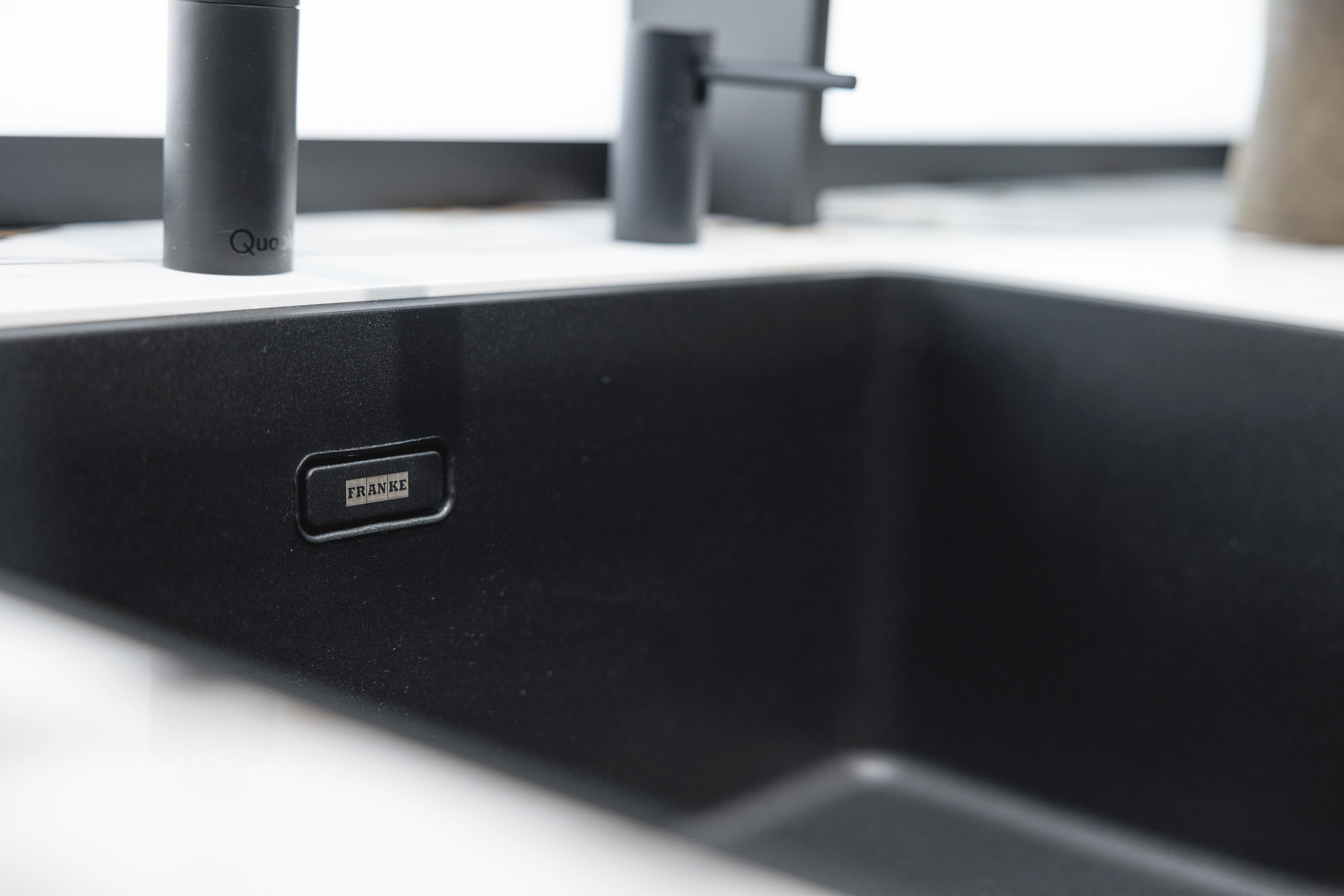 De zwarte spoelbak biedt een mooi contrast met het lichte keramische werkblad.