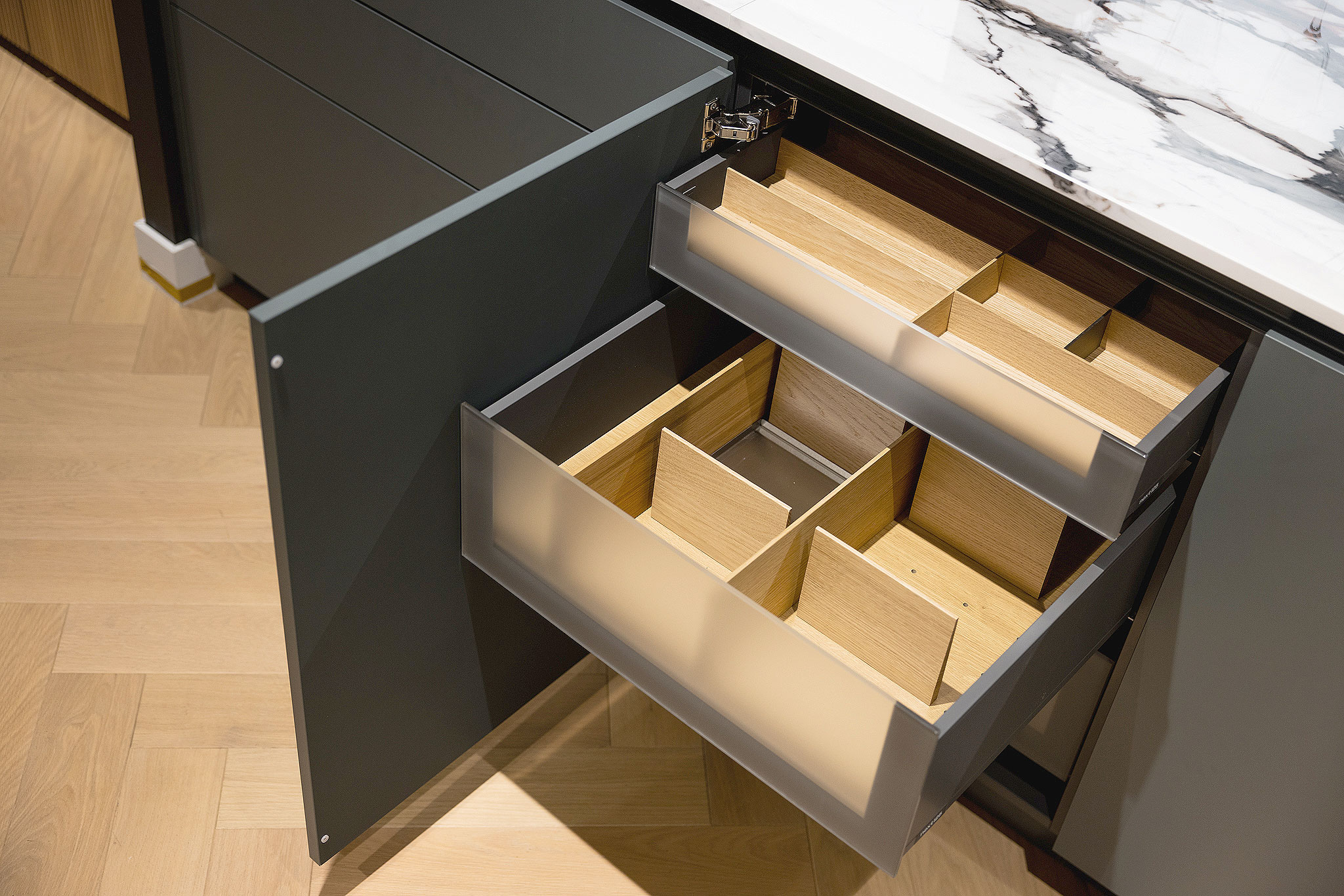 De transparante mat glazen fronten van de binnen lades zetten de hoge designeisen achter het front voort.