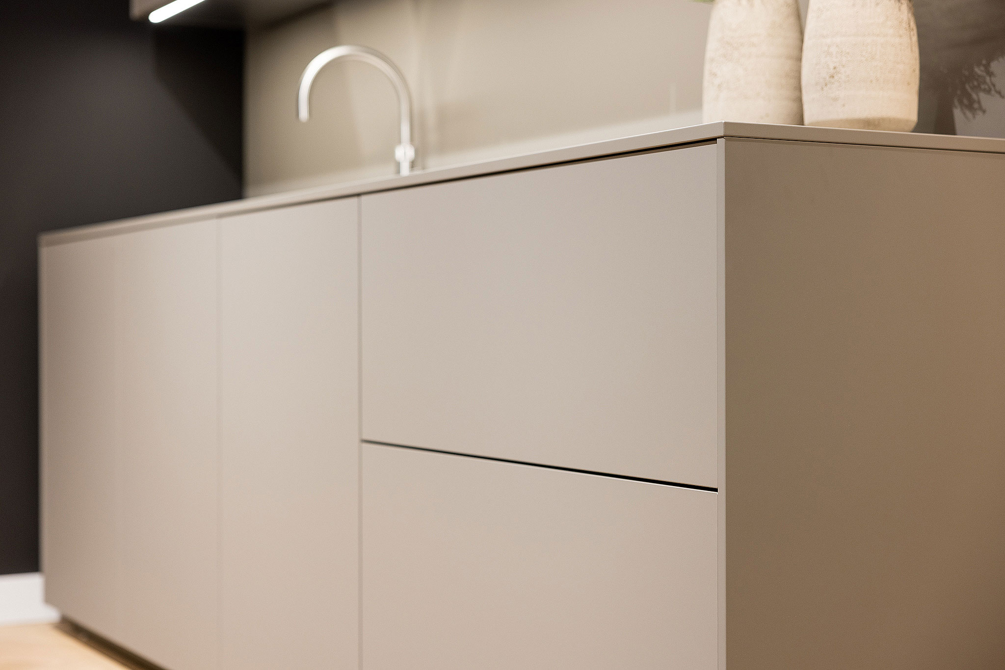 Deze eilandkeuken met hoge kastenwand straalt een en al rust uit.