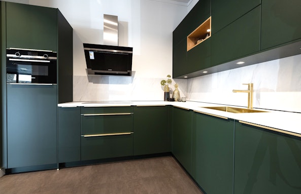 Diepgroene hoekkeuken met gouden accenten
