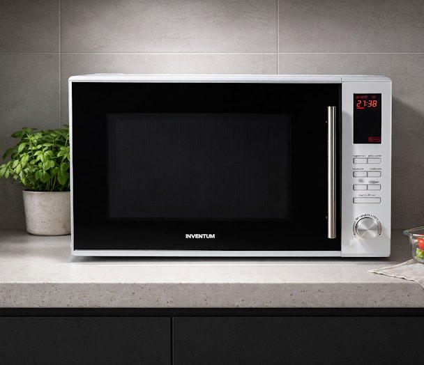Inventum vrijstaande magnetron met digitaal display en draaiknop op grijs aanrecht naast plant
