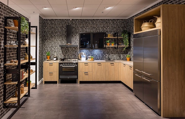 Stoere keukenopstelling met baksteenmotief en open elementen