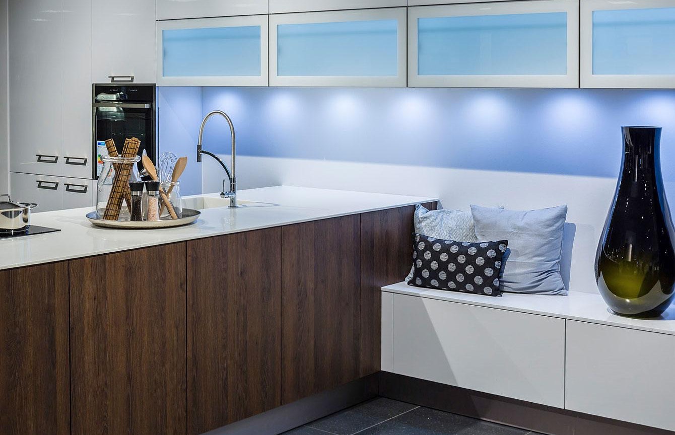Deze design keuken bestaat uit een combinatie van hoogglans wit met een donkeren warme houtkleur.