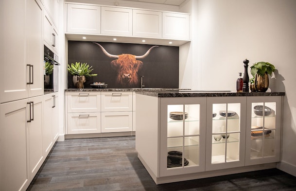 Sfeervolle keukenopstelling met vitrinekast en expressie