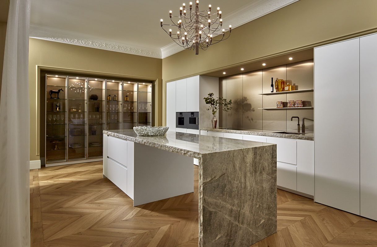 Arctiswitte keuken met bronsaccenten en vitrinekast