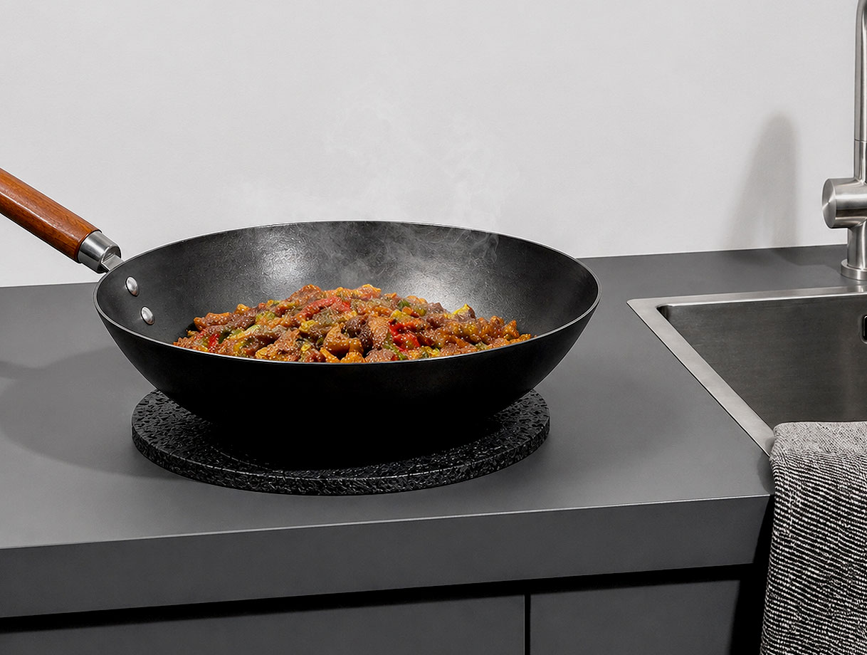 Greengridz keukenblad met hete wokpan op onderzetter naast een spoelbak in moderne keuken