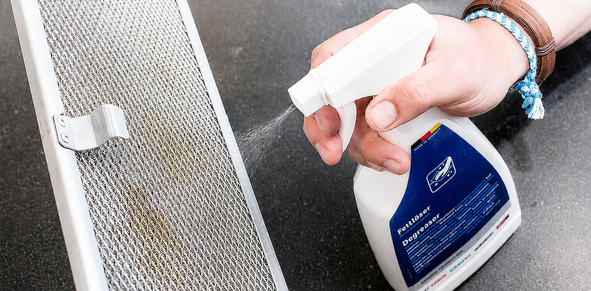 Ontvetter wordt op het vetfilter van de afzuigkap gespoten tegen aangekoekt vet