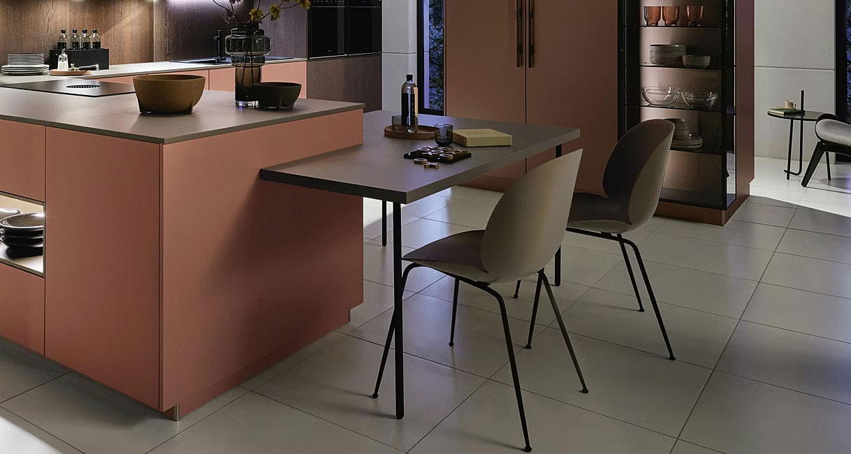 Kookeiland met aangebouwde eettafel voor twee personen en stoelen met vrije loopruimte eromheen