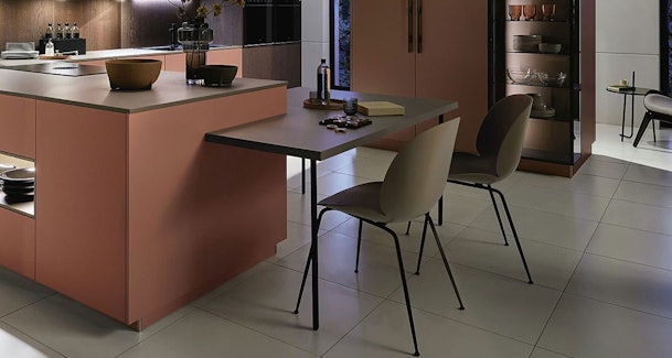 Kookeiland met aangebouwde eettafel voor twee personen en stoelen met vrije loopruimte eromheen