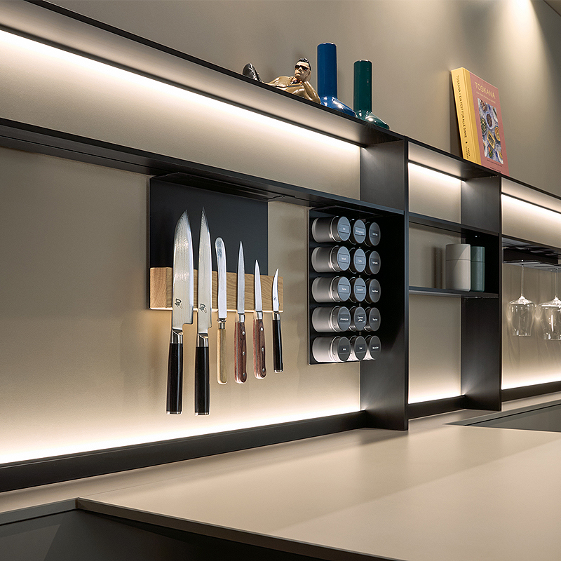 Taupekleurige glazen achterwand met frame nissysteem.