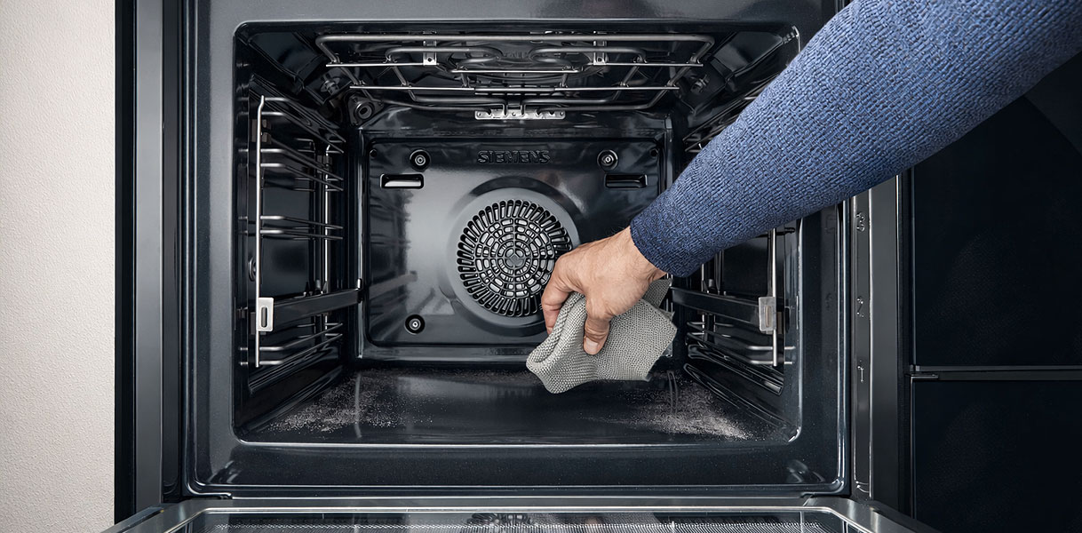 Hand reinigt binnenkant van Siemens magnetron met het activeClean zelfreinigend systeem