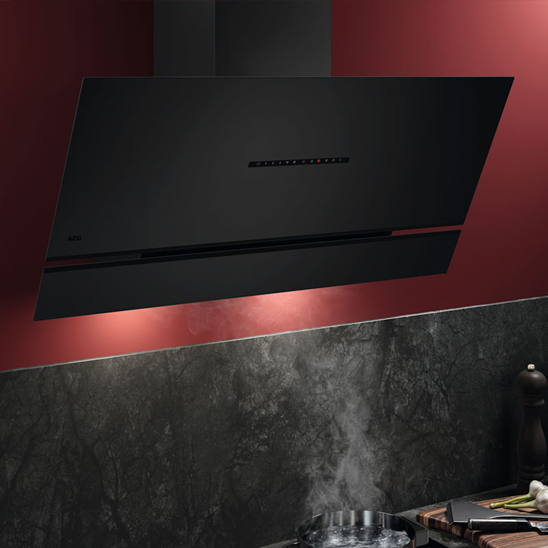 AEG schuine afzuigkap in zwarte uitvoering boven kookplaat met opstijgende stoom