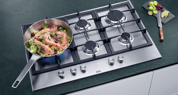 Pan met scampi op de brander van een AEG gaskookplaat met wokbrander