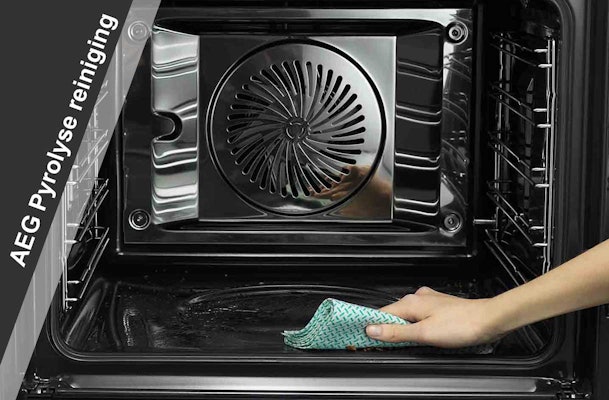 Hand veegt asresten weg uit een AEG oven na pyrolyse reiniging