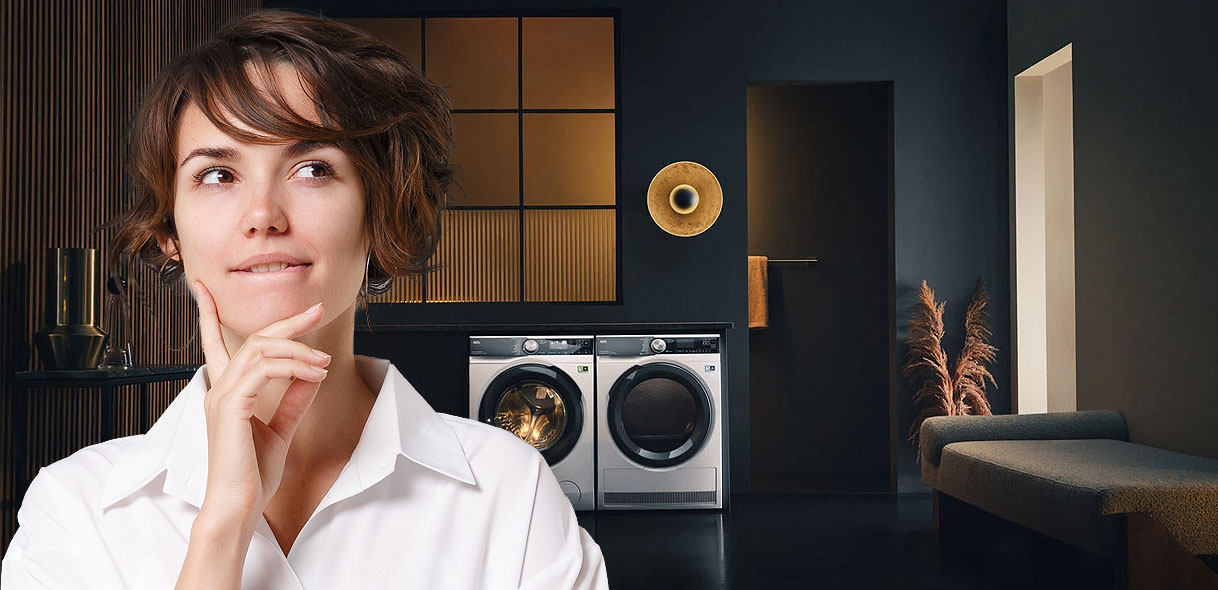 Vrouw denkt na bij wasmachine en droger in moderne wasruimte