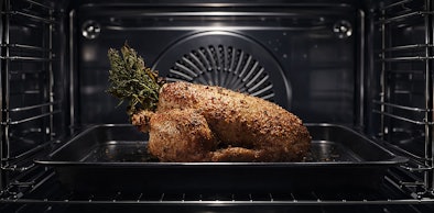 AEG zwarte magnetron met knapperig gebraden kip op rooster dankzij CombiQuick technologie