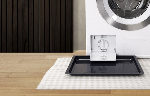 Open afvoerfilter van een wasmachine met opvangbak voor restwater