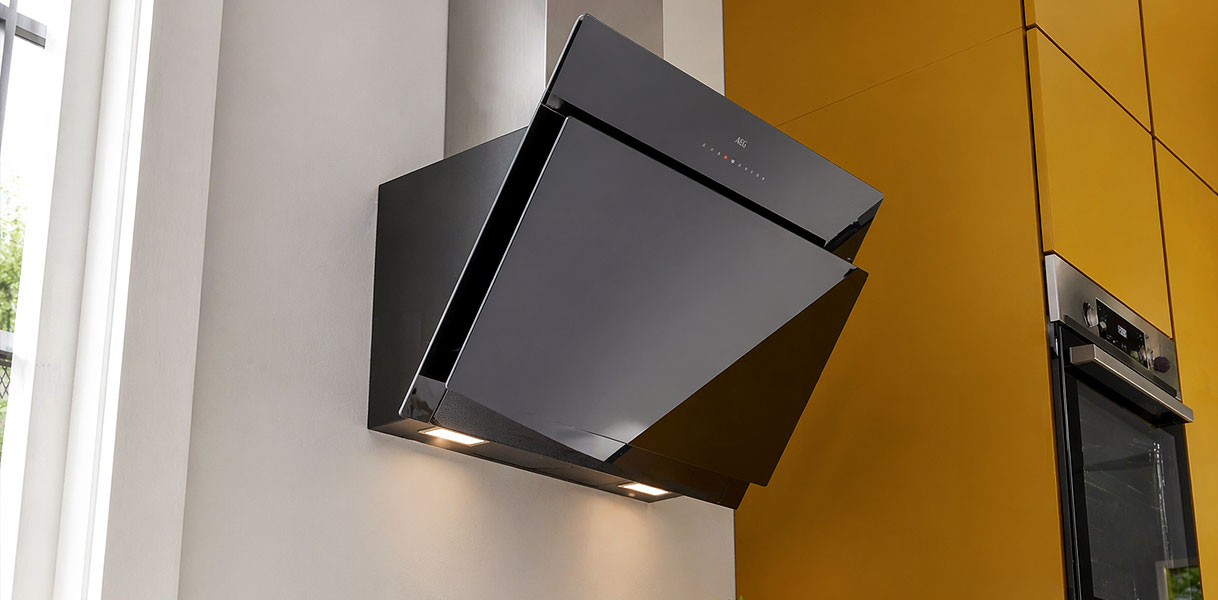 Schuine wandschouwkap met verlichting in keuken naast inbouwoven