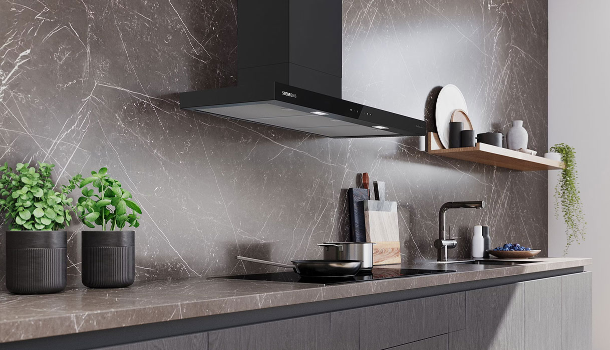 Zwarte afzuigkap van 90 cm boven een brede inductiekookplaat in een moderne keuken.