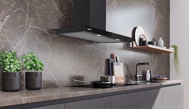Zwarte afzuigkap van 90 cm boven een brede inductiekookplaat in een moderne keuken.