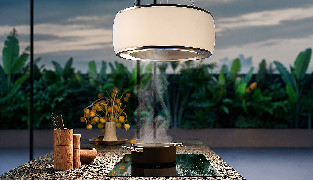 Falmec design afzuigkap met geïntegreerde verlichting boven een kookeiland met dampende pan