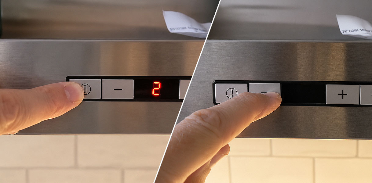 Vinger drukt op de resetknop van het bedieningspaneel van een afzuigkap met display
