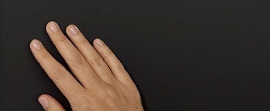 Hand op mat zwart keukenfront met anti-vingerafdruk coating.