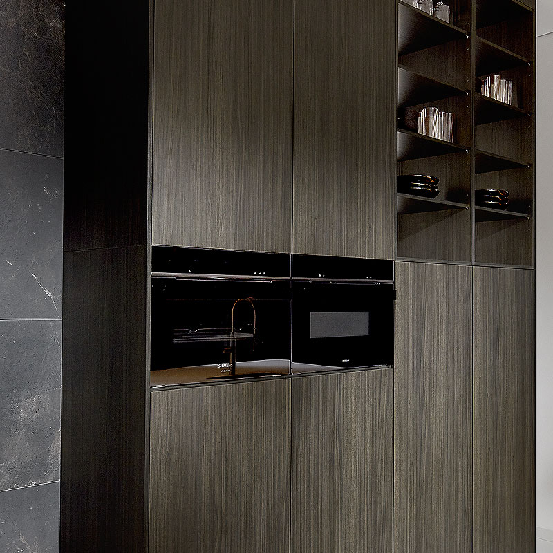 Donkere apparatenwand met houtnerf en open vakken.