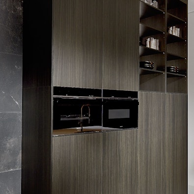 Donkere apparatenwand met houtnerf en open vakken.